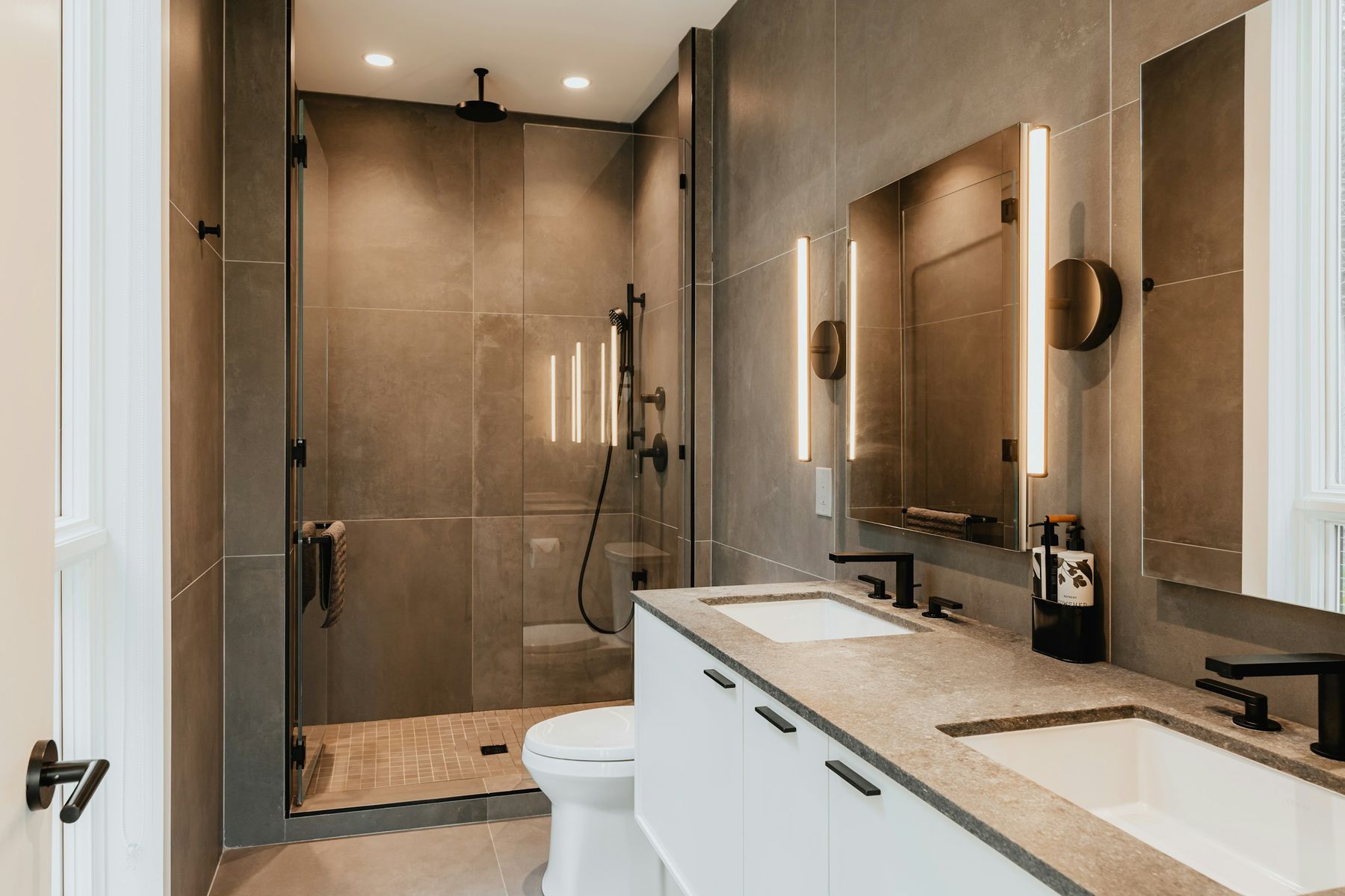 Douche à l’italienne en grès gris, paroi vitrée, double vasque